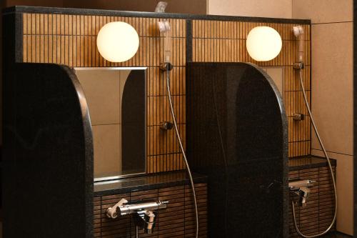 a bathroom with a mirror and a sink at The Centurion Hotel & Spa Classic Izumo in Izumo