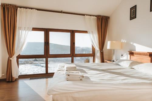 a bedroom with a large bed with a large window at The K Guest House in Cluj-Napoca