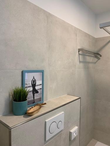 a bathroom with a picture of a person doing yoga at Strandresidenz Villa Verdi in Kühlungsborn
