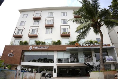 a building with a palm tree in front of it at HOTEL OCEAN VISTA BAY in Visakhapatnam