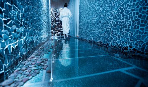a man walking into a room with blue tiles at Camp Ripan in Kiruna