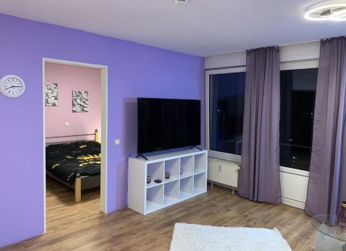 a purple room with a television and a bed at 1 Room, near to UN und Telekom in Bonn