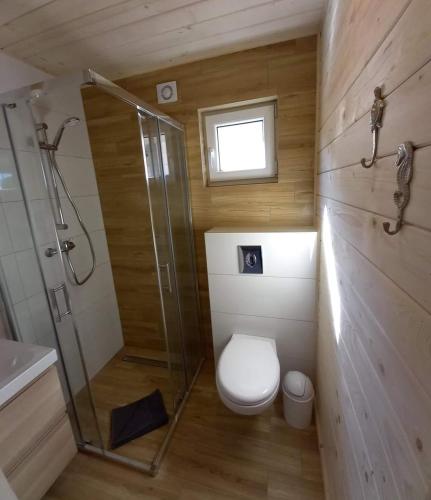a bathroom with a shower and a toilet and a sink at Family Resort Gąski in Gąski
