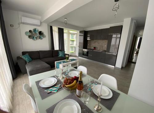 MUR Apartament Alezzi Beach Resort في مامايا نورد نافورداي: غرفة معيشة مع طاولة وكراسي وأريكة