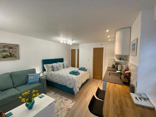 a living room with a bed and a couch at Sweet Caroline - luxury studio stone’s throw from Mousehole harbour in Mousehole