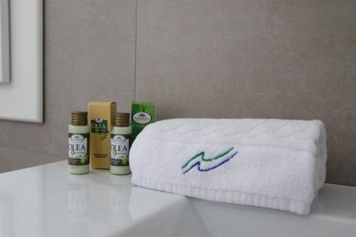 un asciugamano seduto sul bancone del bagno con alcuni prodotti di Verde Blu Vacanze Suites a Porto Cesareo