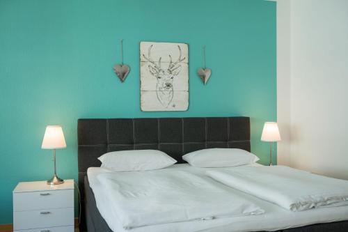 1 dormitorio con 1 cama grande y pared azul en Hotel Neumaier, en Xanten