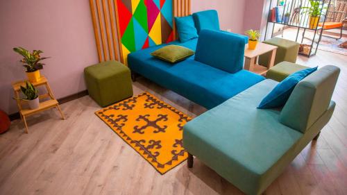 a living room with two blue couches and a rug at People Hostel in Bishkek