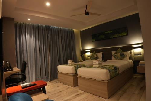 a hotel room with two beds and a couch at HOTEL OCEAN VISTA BAY in Visakhapatnam