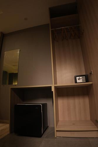 a room with a tv and a shelf and a mirror at HOTEL OCEAN VISTA BAY in Visakhapatnam