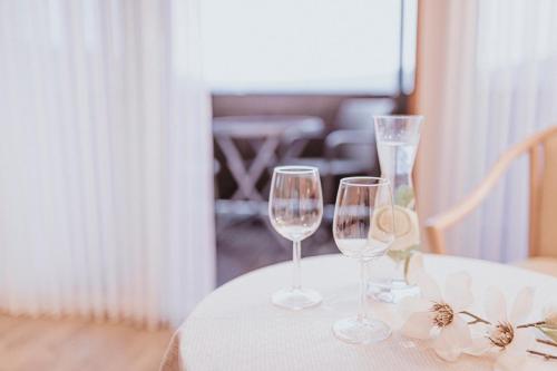 a table with two wine glasses on a white table cloth at PANORAMA Hotel Heimbuchenthal in Heimbuchenthal