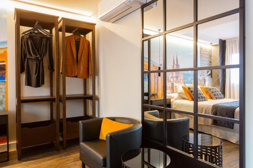 a room with a closet with a bed and a chair at Fly Rooms Madrid Airport in Madrid