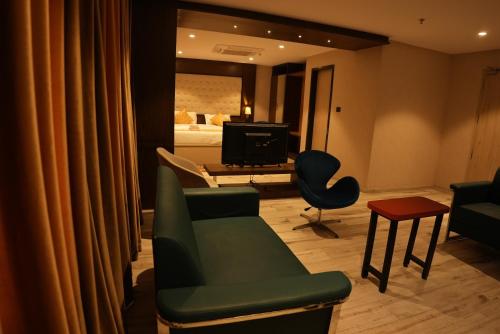a living room with a green couch and a television at HOTEL OCEAN VISTA BAY in Visakhapatnam