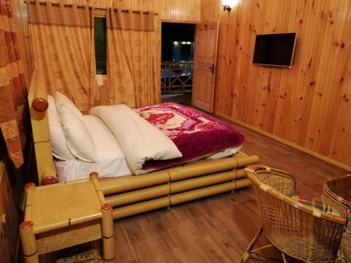 a bedroom with a bed in a wooden room at Swiss Wood Cottages Naran in Nārān