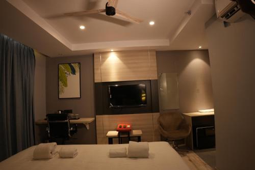 a bedroom with a bed and a kitchen with a tv at HOTEL OCEAN VISTA BAY in Visakhapatnam