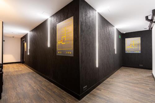 a hallway with black walls and wooden floors at Fly Rooms Madrid Airport in Madrid