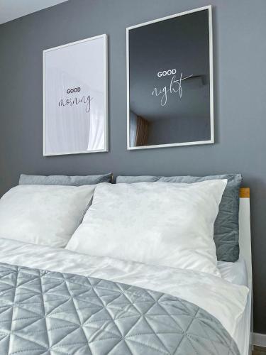 a bedroom with two pictures on the wall and a bed at LAWIS Apartments in Poprad