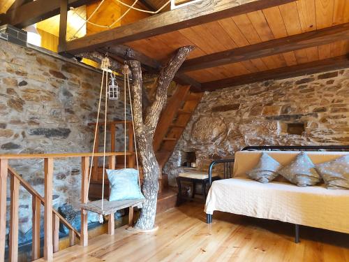 a bedroom with a swinging bed and a stone wall at Casa da Arvore - Paradinha in Paradinha