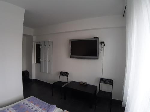 Habitación con TV, mesa y sillas. en Hotelak Martinov, en Ostrava