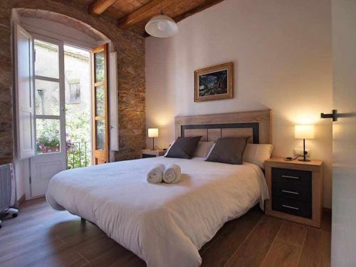 1 dormitorio con 1 cama grande y 2 toallas. en Maravilloso apartamento en el casco antiguo, en Besalú