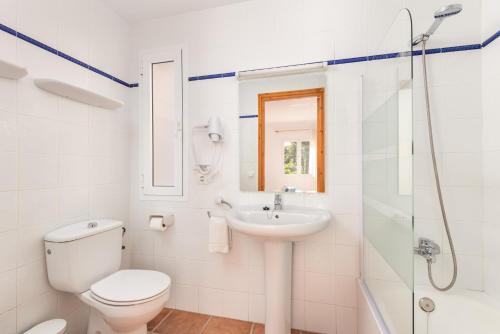 La salle de bains est pourvue de toilettes, d'un lavabo et d'une douche. dans l'établissement Apartamentos Annabel's 2-3 HABITACIONES, à Cala Galdana