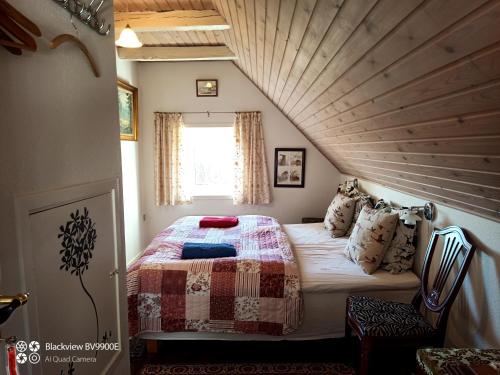 a bed in a room with a wooden ceiling at Tvillinggaard Thy in Vang
