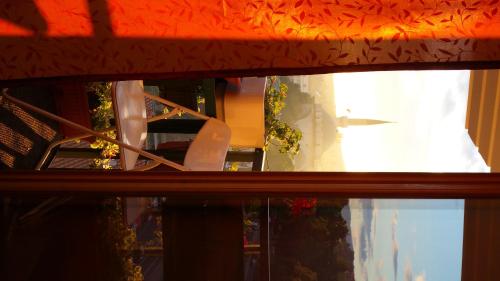 a window with a reflection of a chair in it at Apartments Emily in Sarajevo