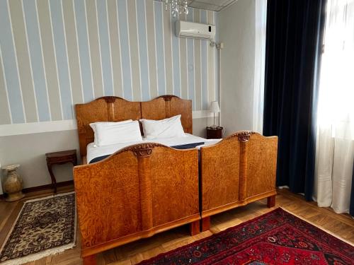 a bedroom with a wooden bed with white pillows at Villa Tergeste in Trieste