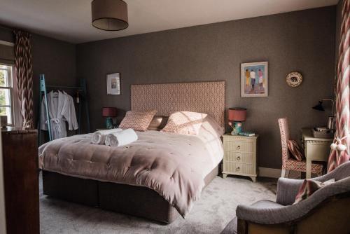 a bedroom with a large bed and a chair at The Naight House in Gloucester