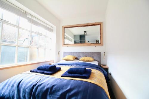 een slaapkamer met een bed met twee blauwe kussens erop bij Alfriston Lodge By Air Premier in Alfriston