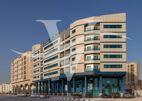Viola Hotel Apartments في الشارقة: مبنى كبير فيه سيارات تقف امامه