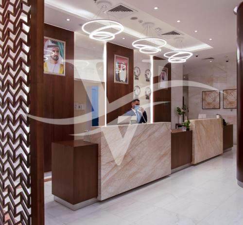 a lobby with a reflection of a man in a mirror at Viola Hotel Apartments in Sharjah