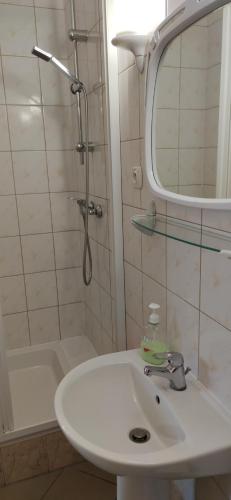 y baño con lavabo y ducha con espejo. en Usługi hotelarskie Helena, en Siemiatycze