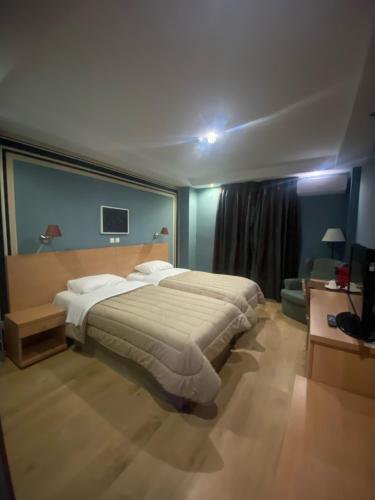 
a hotel room with a bed and a desk at Athina Airport Hotel in Thermi
