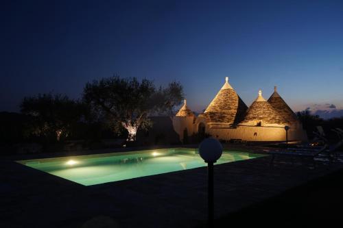 a house with a swimming pool at night at Quattroperle Trulli - Relax - Puglia in Castellana Grotte