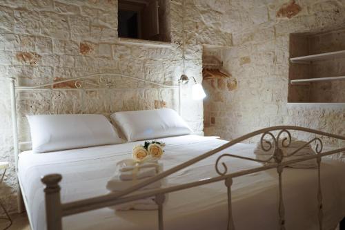 sypialnia z białym łóżkiem z białą pościelą w obiekcie Quattroperle Trulli - Relax - Puglia w mieście Castellana Grotte