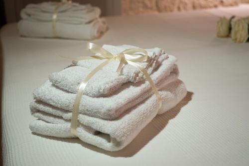 une pile de serviettes assises au-dessus d'un lit dans l'établissement Quattroperle Trulli - Relax - Puglia, à Castellana Grotte