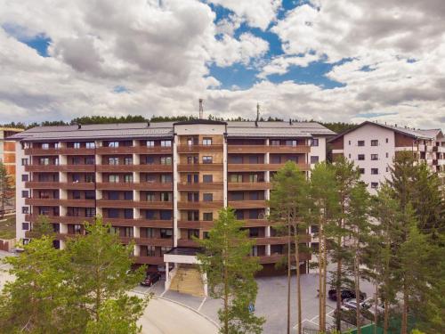an apartment building with trees in front of it at Balkan Hill Zlatibor in Zlatibor