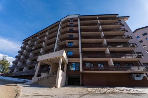 a tall apartment building with stairs in front of it at Balkan Hill Zlatibor in Zlatibor