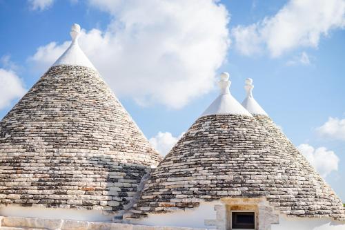 two pointy towers of a building with a sky in the background at Quattroperle Trulli - Relax - Puglia in Castellana Grotte