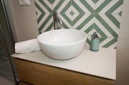 a white bowl sink on a counter in a bathroom at Quattroperle Trulli - Relax - Puglia in Castellana Grotte