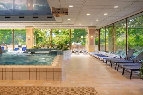 a large pool in a building with chairs around it at Ensana Grand Margaret Island in Budapest