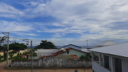 a house with a fence and a blue sky at 3º andar independente - Casa a 50m da praia com vista lateral para o mar in Saquarema