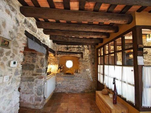 a room with a stone wall and a kitchen at Masia with pool and beautiful views near Girona in Girona
