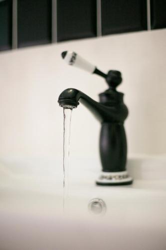 a water faucet with a toothbrush in it on a sink at Kamienica Boutique ApartHotel in Białystok