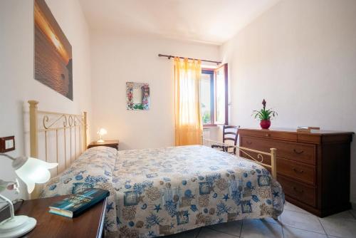 a bedroom with a bed and a dresser and a window at Appartamenti L'Arcipelago in Marina di Campo