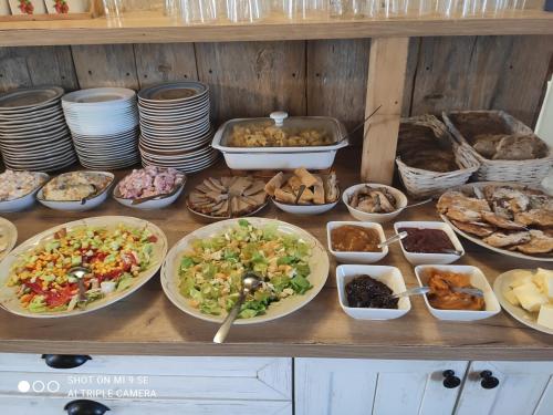 a table with many plates of food on it at Folwark Malinowy Chruśniak in Bisztynek