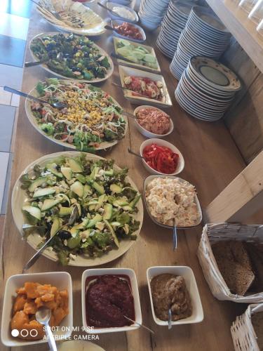 a table with many different plates of food on it at Folwark Malinowy Chruśniak in Bisztynek