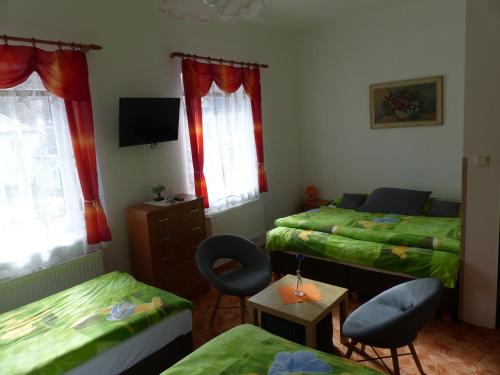 sypialnia z 2 łóżkami, stołem i krzesłami w obiekcie Villa Plischke w mieście Lipova Lazne