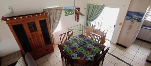 a dining room with a table with flowers on it at sandpiper in Jeffreys Bay